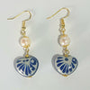 ARETES CORAZON TRIDIMENSIONAL INFLADO DECORADO AZUL COBALTO CON PERLA DEL RIO