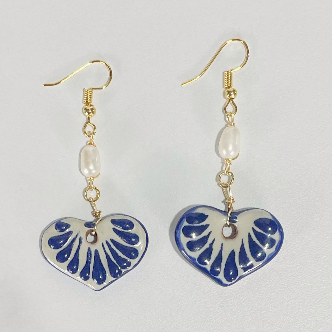 ARETES CORAZON PLANO CERRADO FONDO TRADICIONAL DECORADO AZUL COBALTO CON PERLA DEL RIO