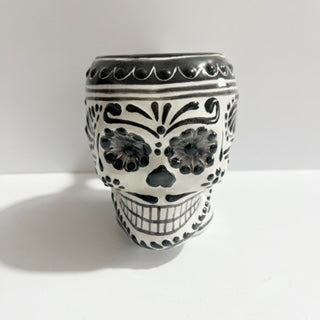 TAZA FORMA DE CRANEO FONDO BLANCO, DECORADO NEGRO.